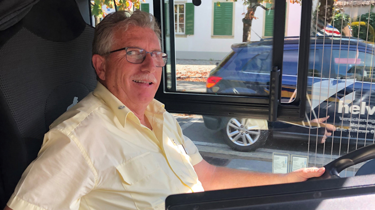 Ein Postauto von grünen Wiesen umgeben